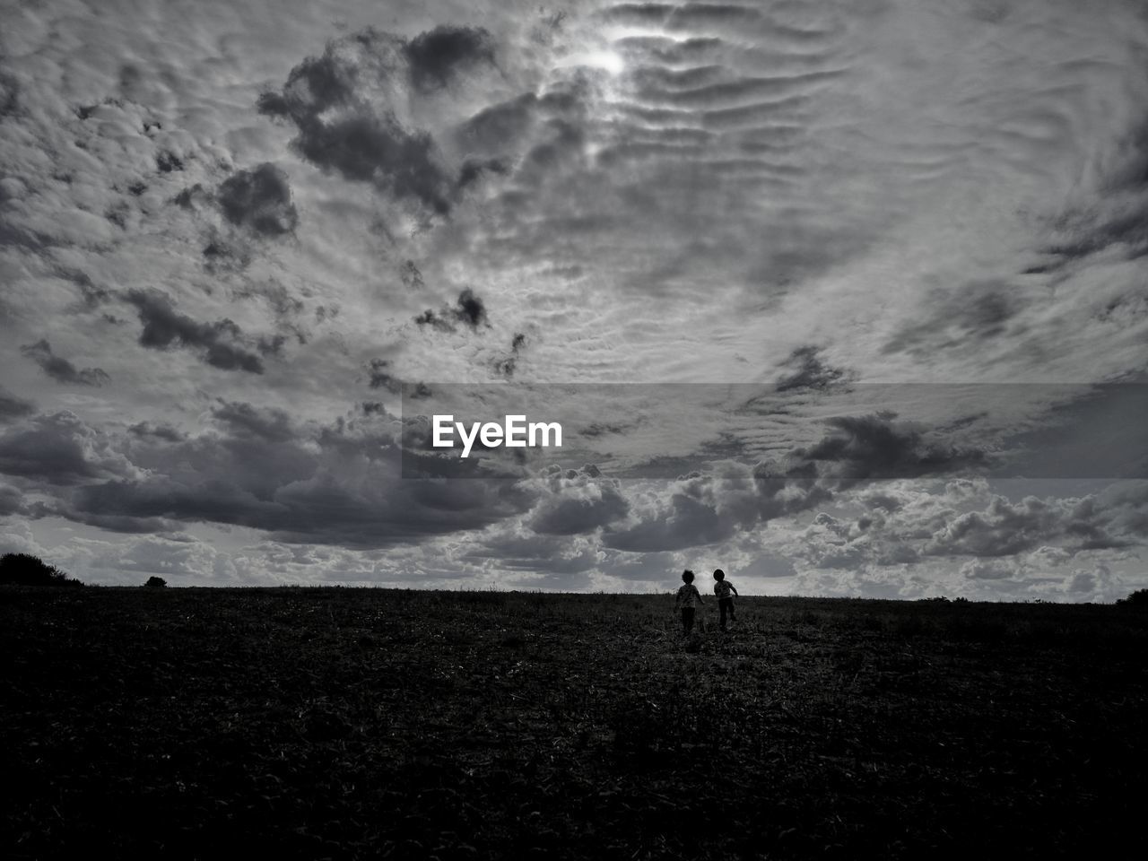 Silhouette people standing on field against sky