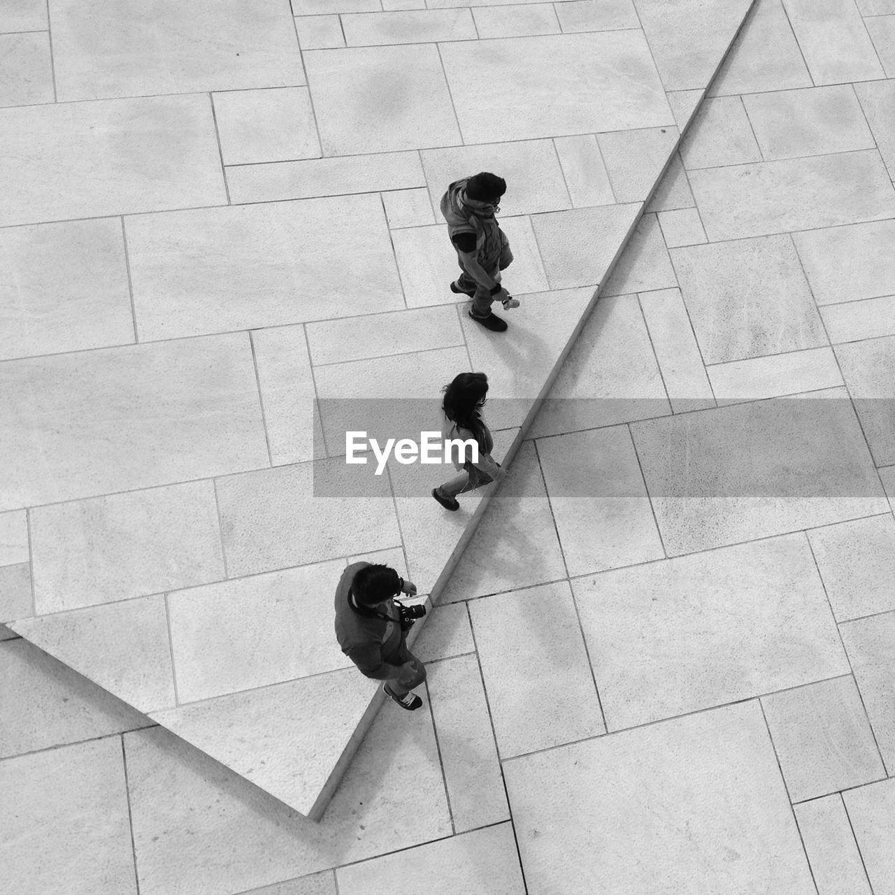 High angle view of people walking on tiled flooring