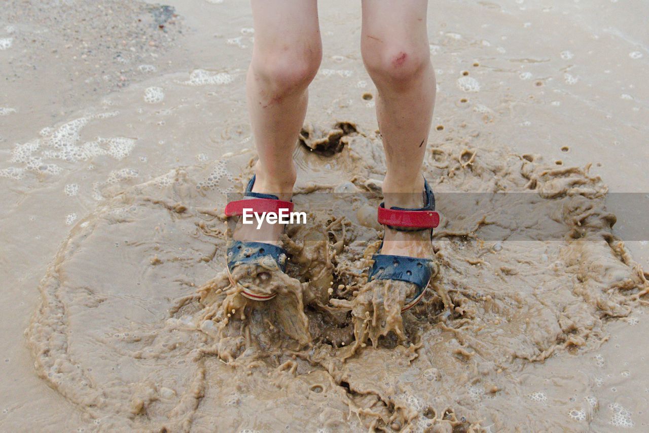 Low section of child jumping on beach