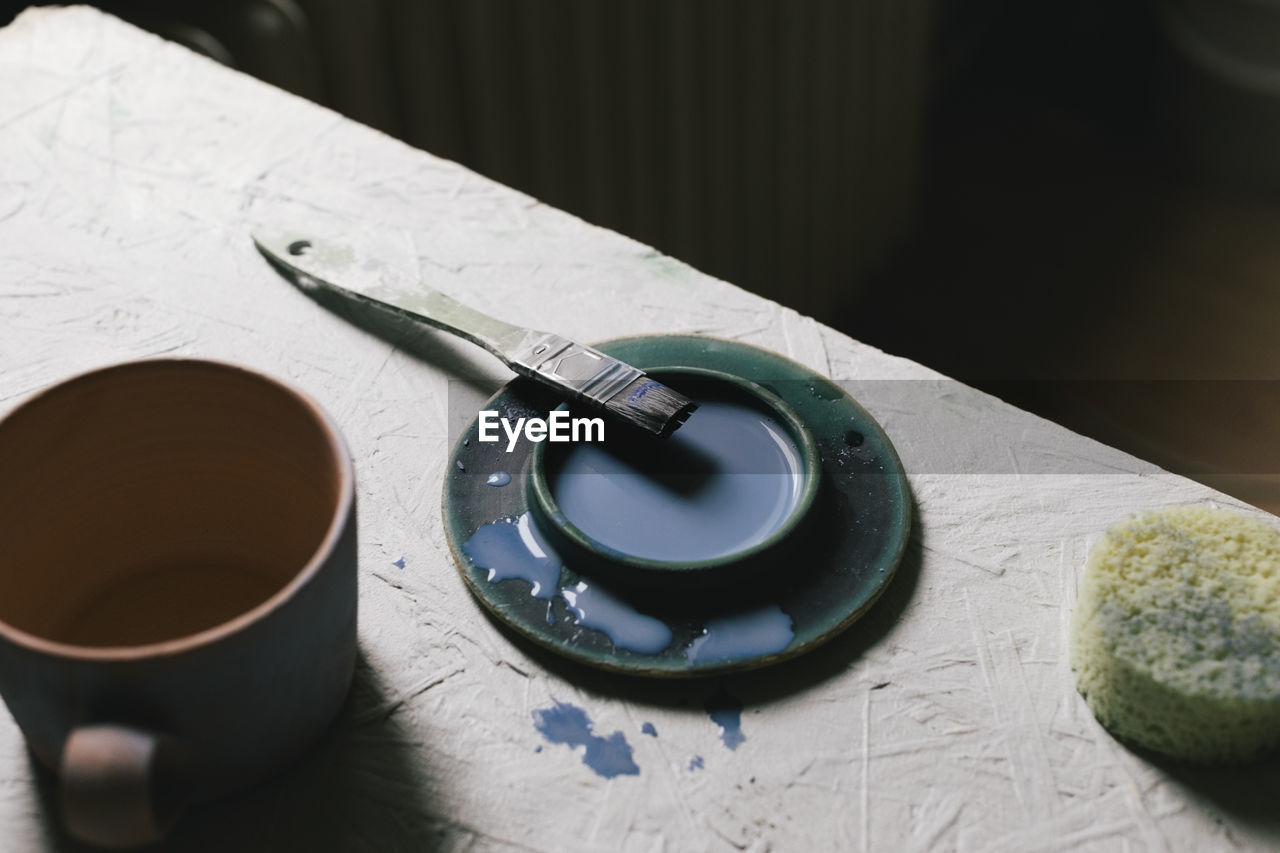 High angle view of paint and paintbrush at table