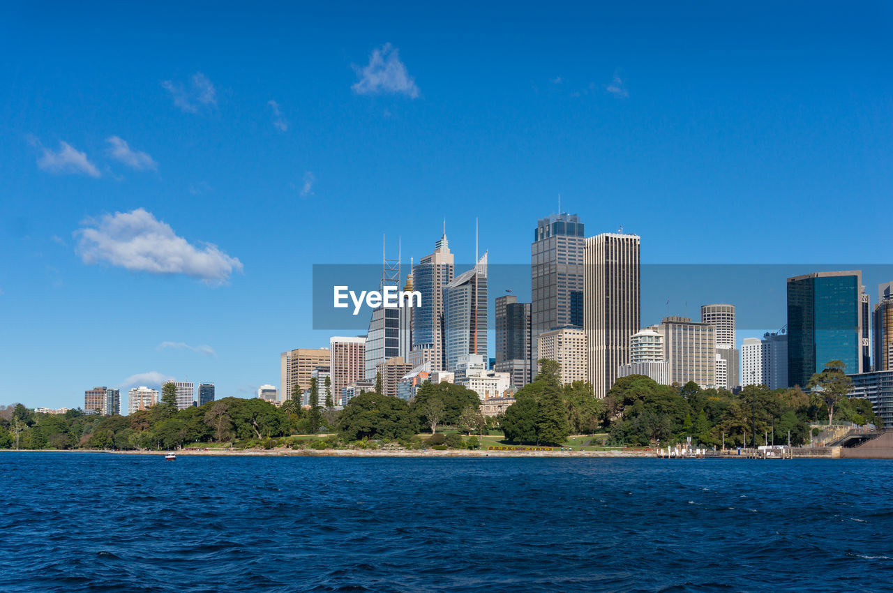 Modern buildings in city against blue sky