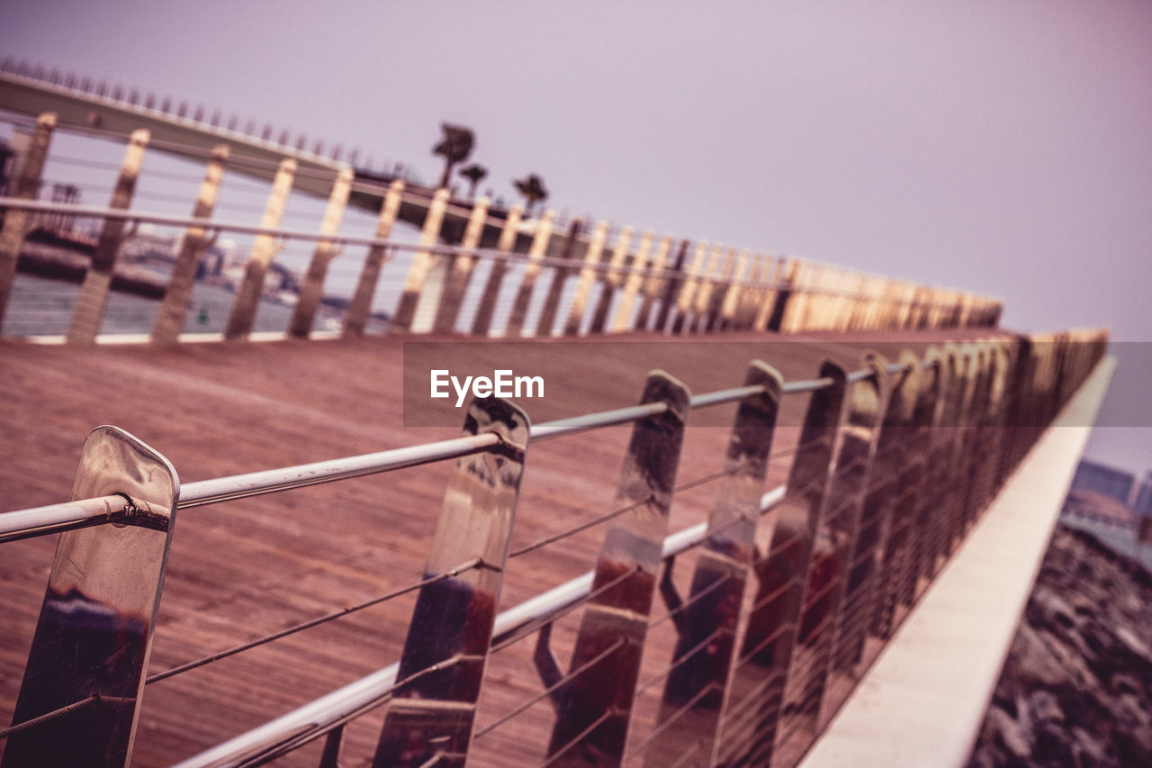 CLOSE-UP OF METAL RAILING AGAINST SKY