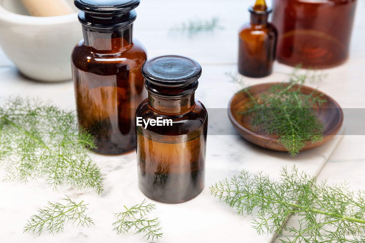 Fennel essential oil on amber bottles. herbal oil for skin care, aromatherapy and natural medicine