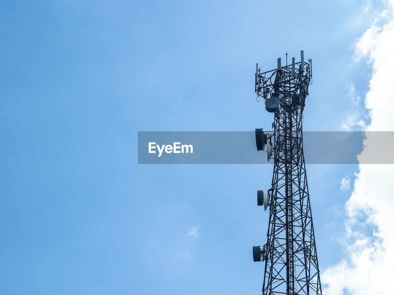 Low angle view of communications tower against blue sky