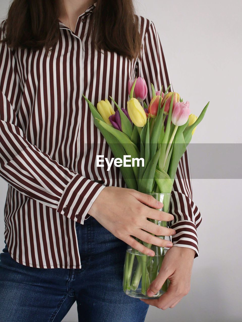 Midsection of woman holding colorful tulips