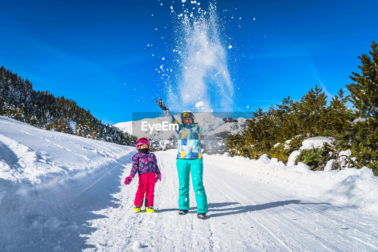 Mother and daughter, family, throwing snow powder up to the air, andorra, pyrenees