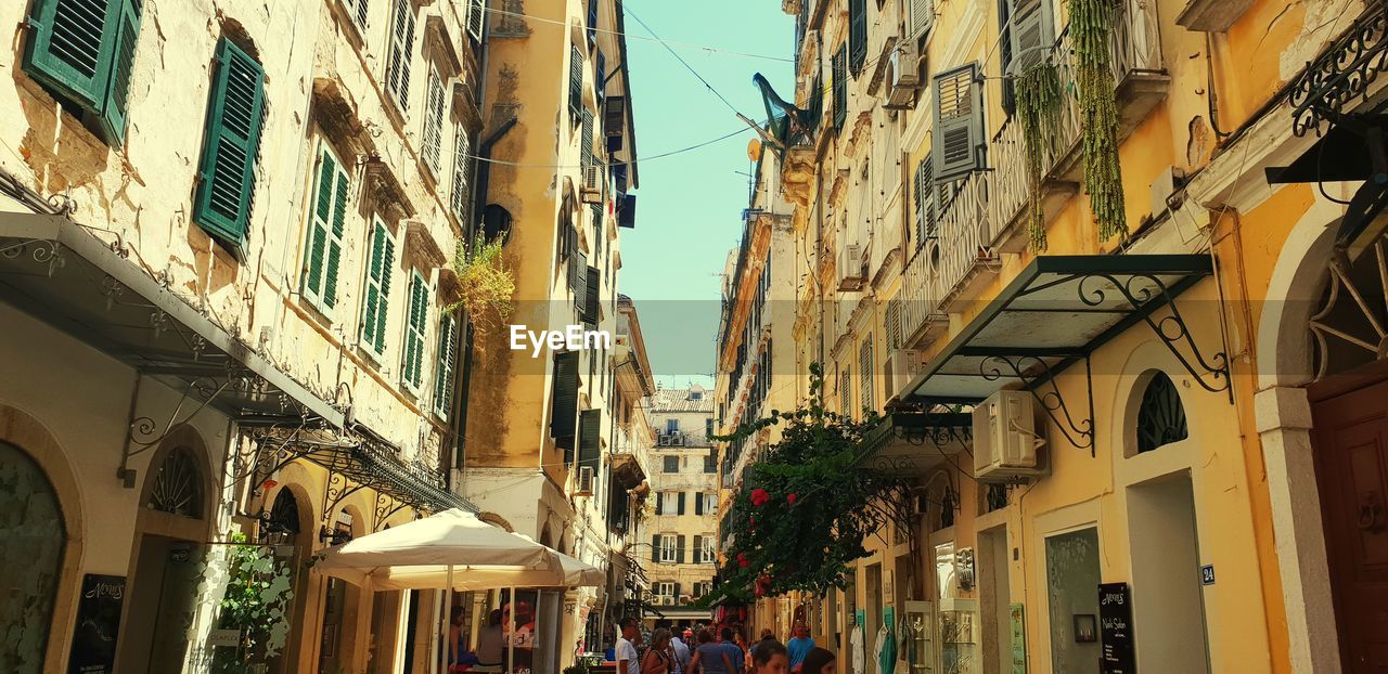 LOW ANGLE VIEW OF BUILDINGS AMIDST STREET IN CITY