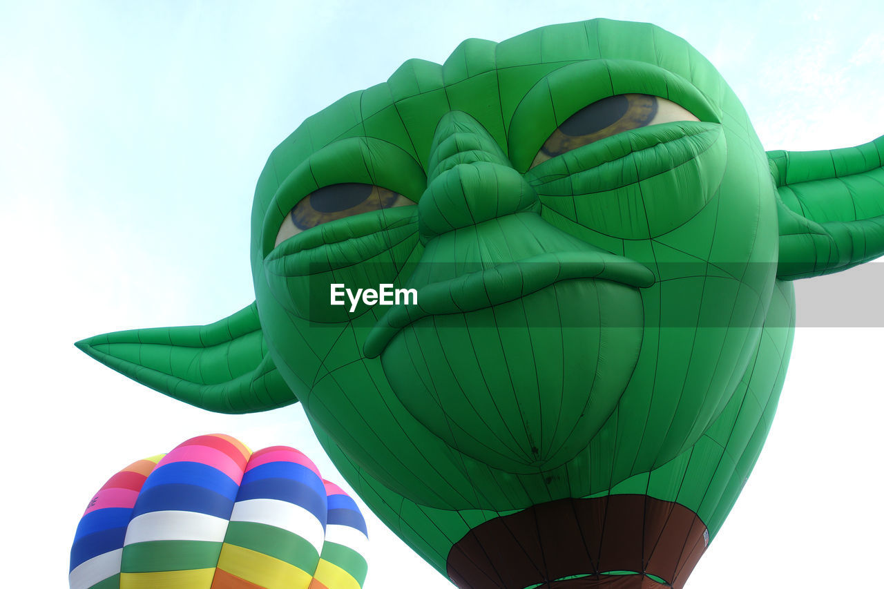 CLOSE-UP OF HOT AIR BALLOONS AGAINST SKY