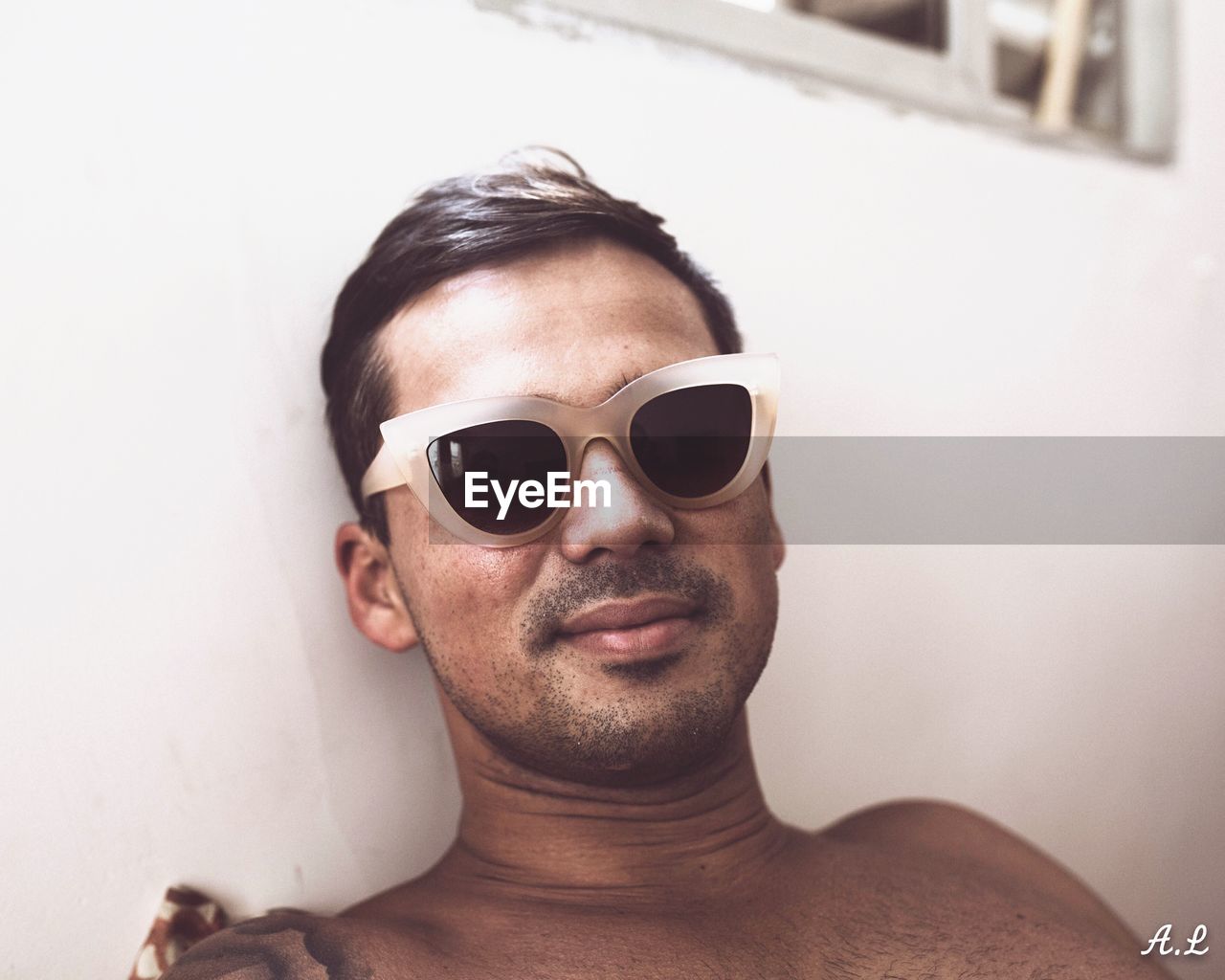 CLOSE-UP PORTRAIT OF MAN WEARING SUNGLASSES IN EYEGLASSES