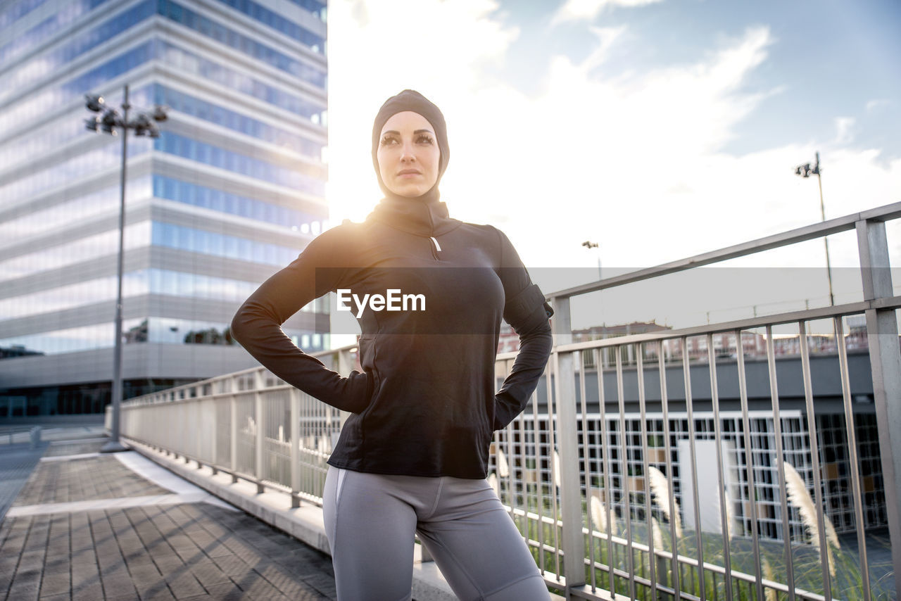 Beautiful woman standing against building in city