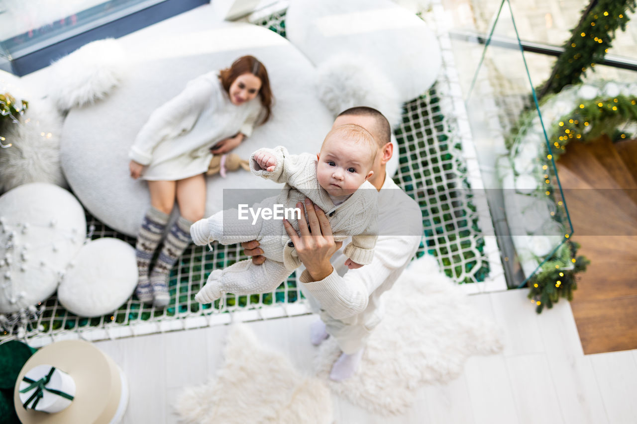 High angle view of young family with newborn baby in modern house
