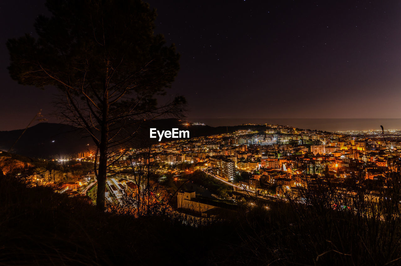 High angle view of illuminated buildings against sky at night