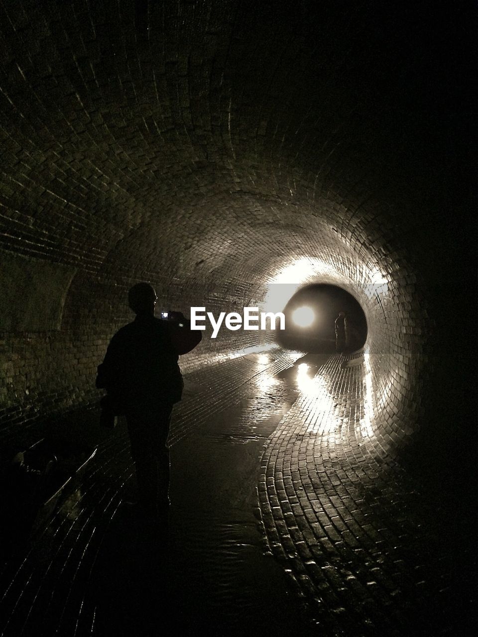 Rear view of man in dark tunnel