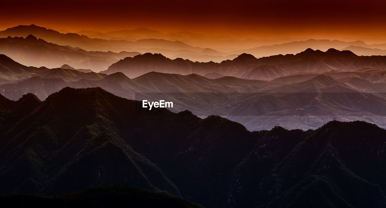 Scenic view of silhouette mountains against sky at sunset