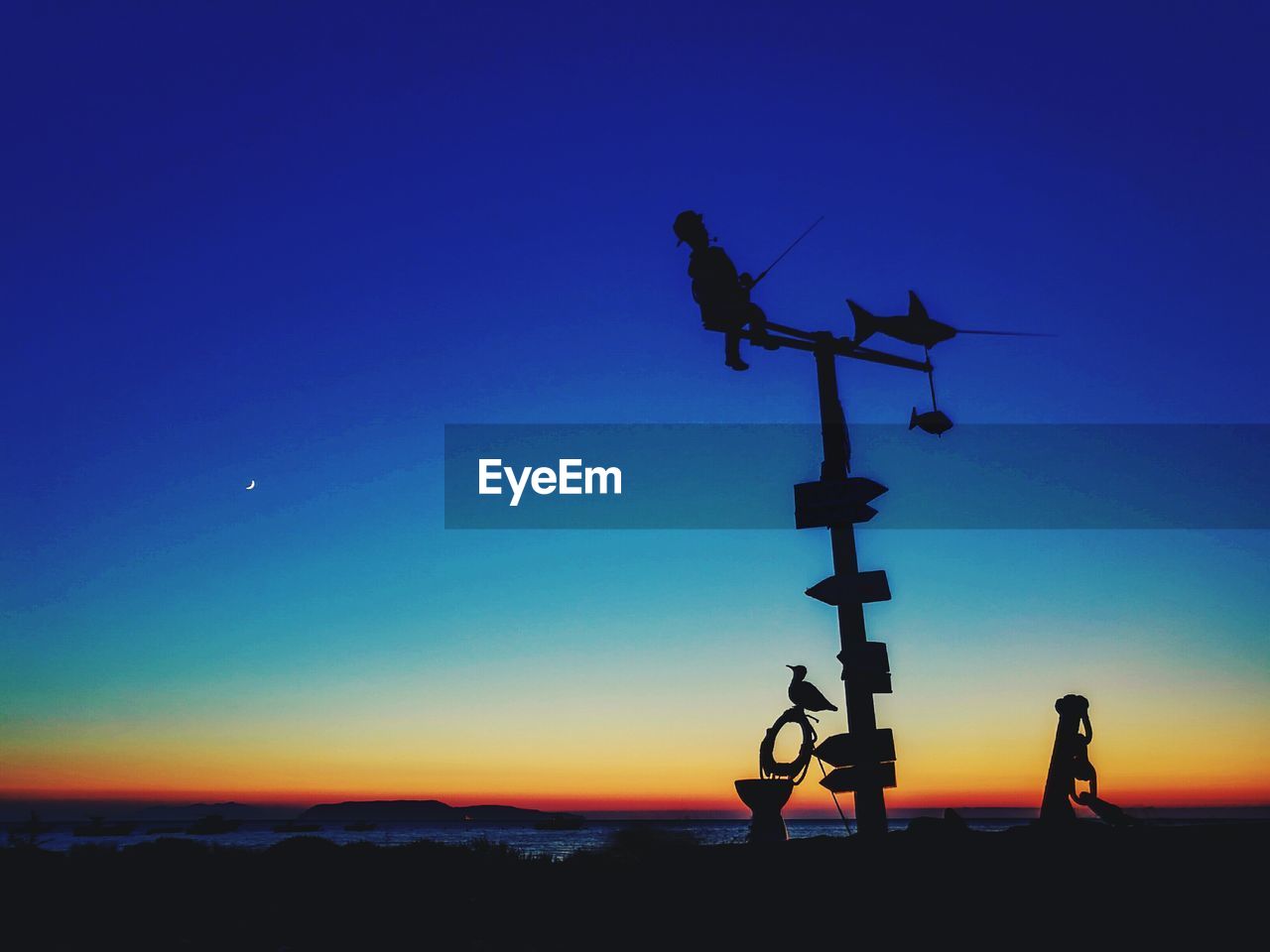 LOW ANGLE VIEW OF WEATHER VANE AGAINST BLUE SKY