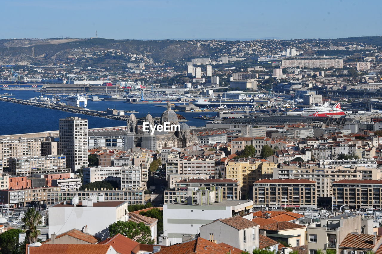 High angle view of townscape by sea against sky