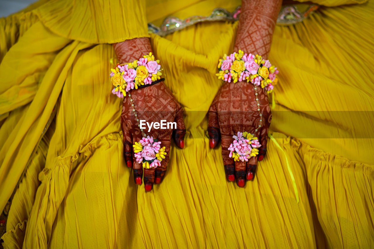 Close up of bride hands with flowers on his fingers 