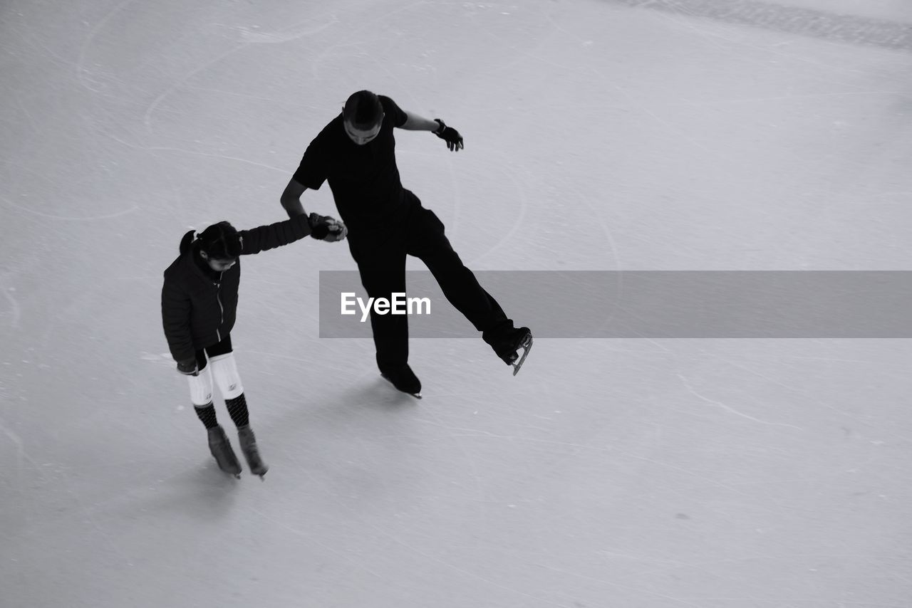 High angle view of father and son ice-skating on rink