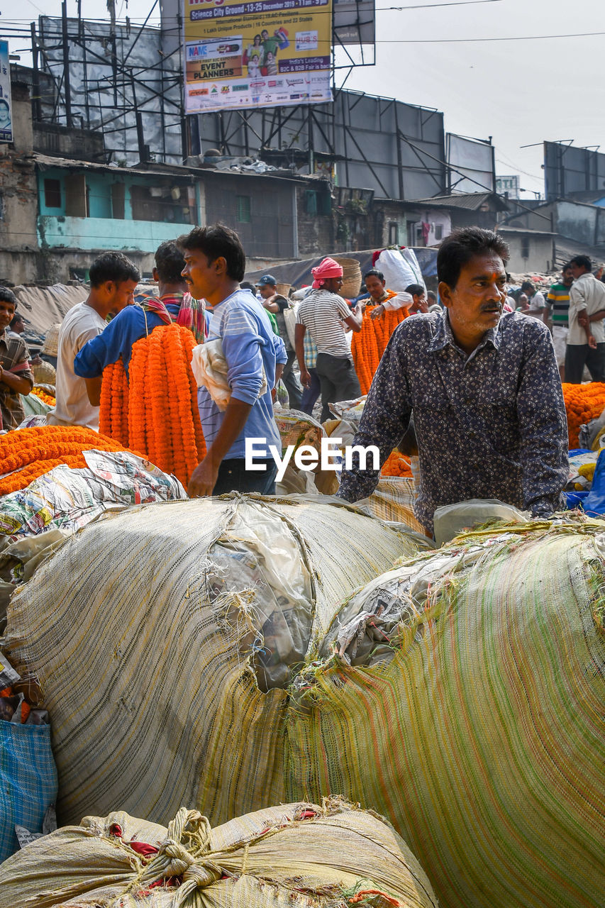 REAR VIEW OF PEOPLE WORKING AT CONSTRUCTION SITE