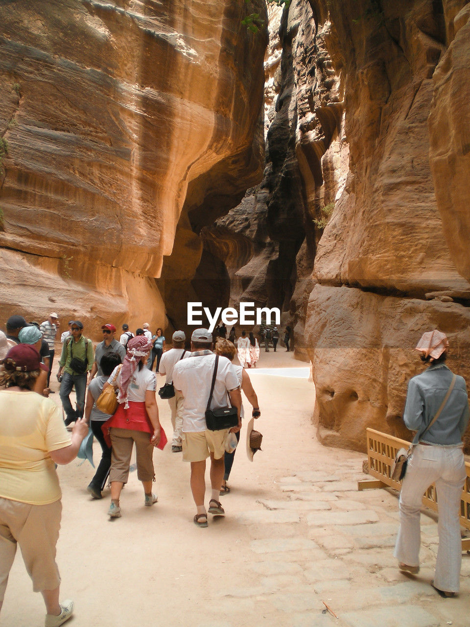 group of people, rock, rock formation, travel, adult, travel destinations, full length, men, women, tourism, walking, nature, leisure activity, wadi, architecture, tourist, formation, activity, canyon, trip, holiday, cave, vacation, history, adventure, arch, outdoors, footwear, land, lifestyles, temple, medium group of people, geology, day, ancient history, physical geography, the past, rear view, exploration