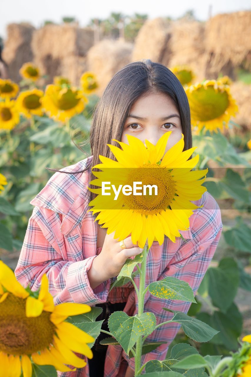 Portrait of woman with yellow sunflower