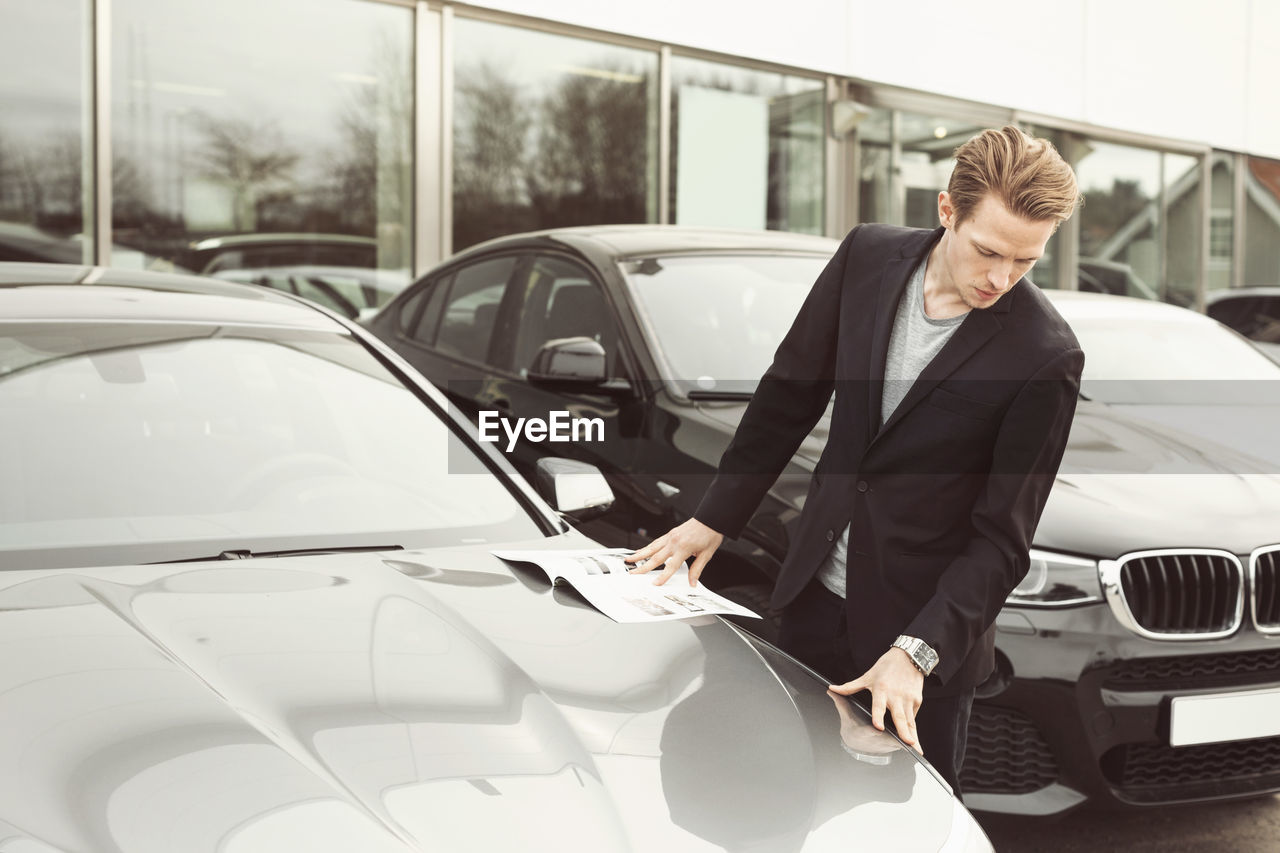 Man examining car outside showroom