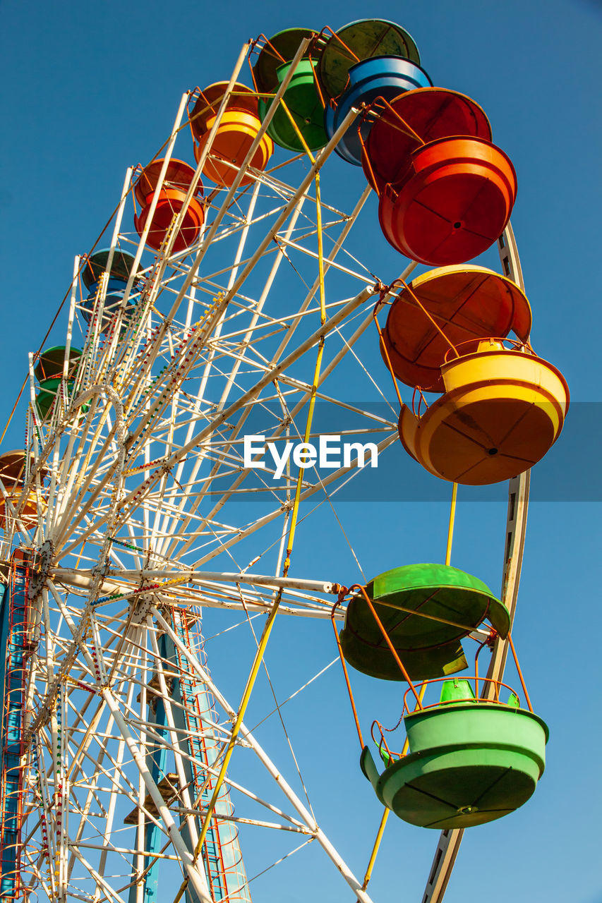 Colorful booths of the ferris wheel on blue sky background