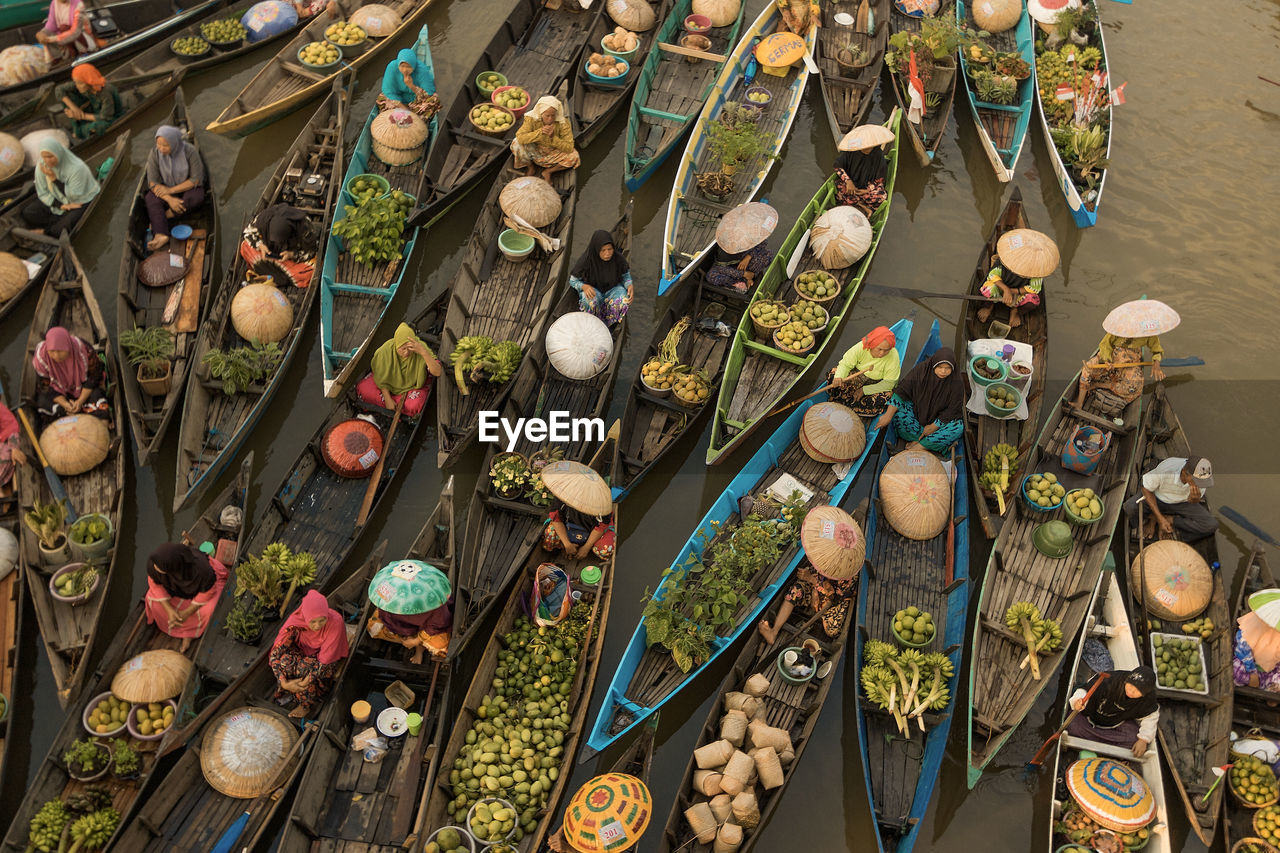 Aerial view of people in boat by vegetables for sale in market
