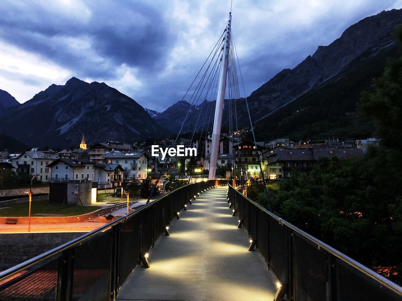 Bridge over river in city against sky