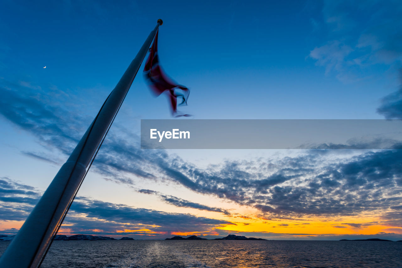 LOW ANGLE VIEW OF FLAG AGAINST SKY DURING SUNSET