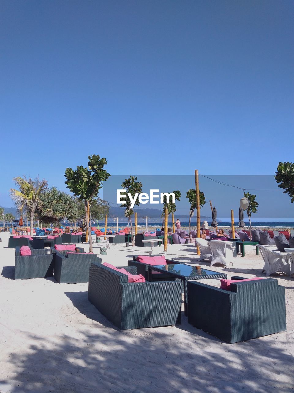 CHAIRS BY SWIMMING POOL AGAINST CLEAR SKY