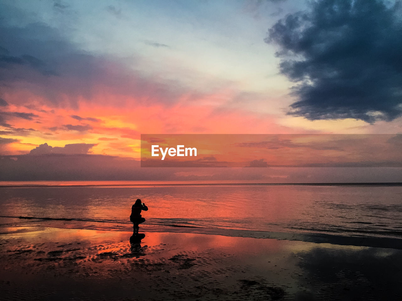 Silhouette man standing on beach against sky during sunset