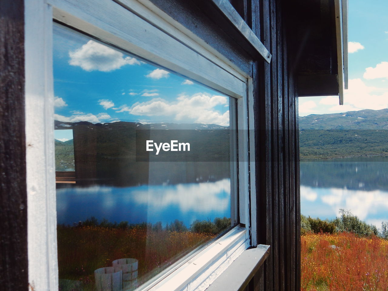 Reflection of mountain and lake on house window