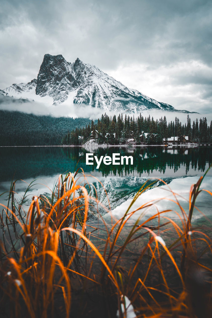 Scenic view of lake by snowcapped mountains against sky