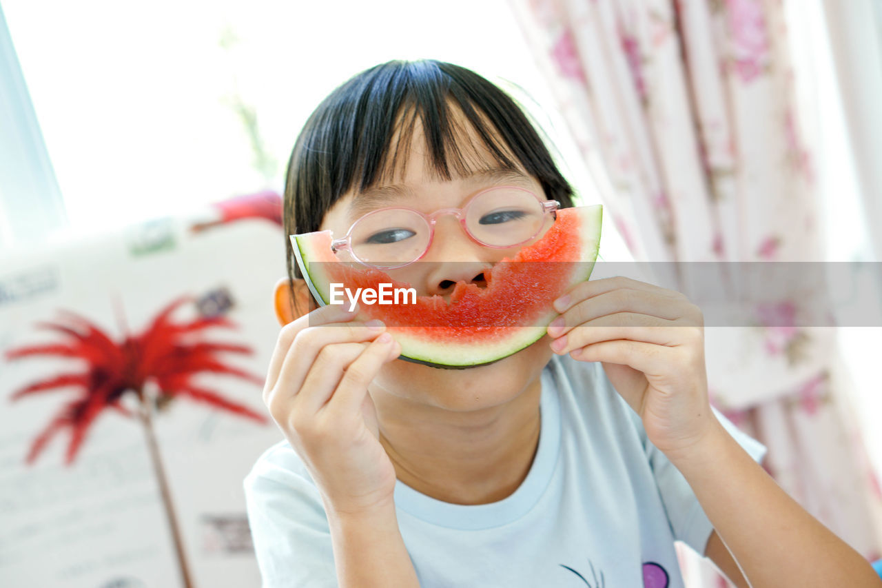 Close-up portrait of a boy eating fruit