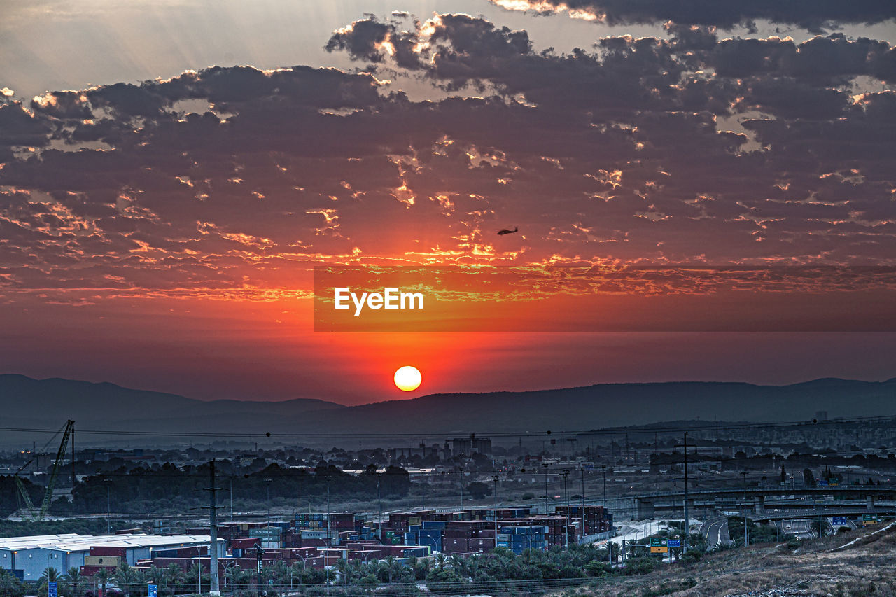 HIGH ANGLE VIEW OF BUILDINGS AGAINST SKY DURING SUNSET