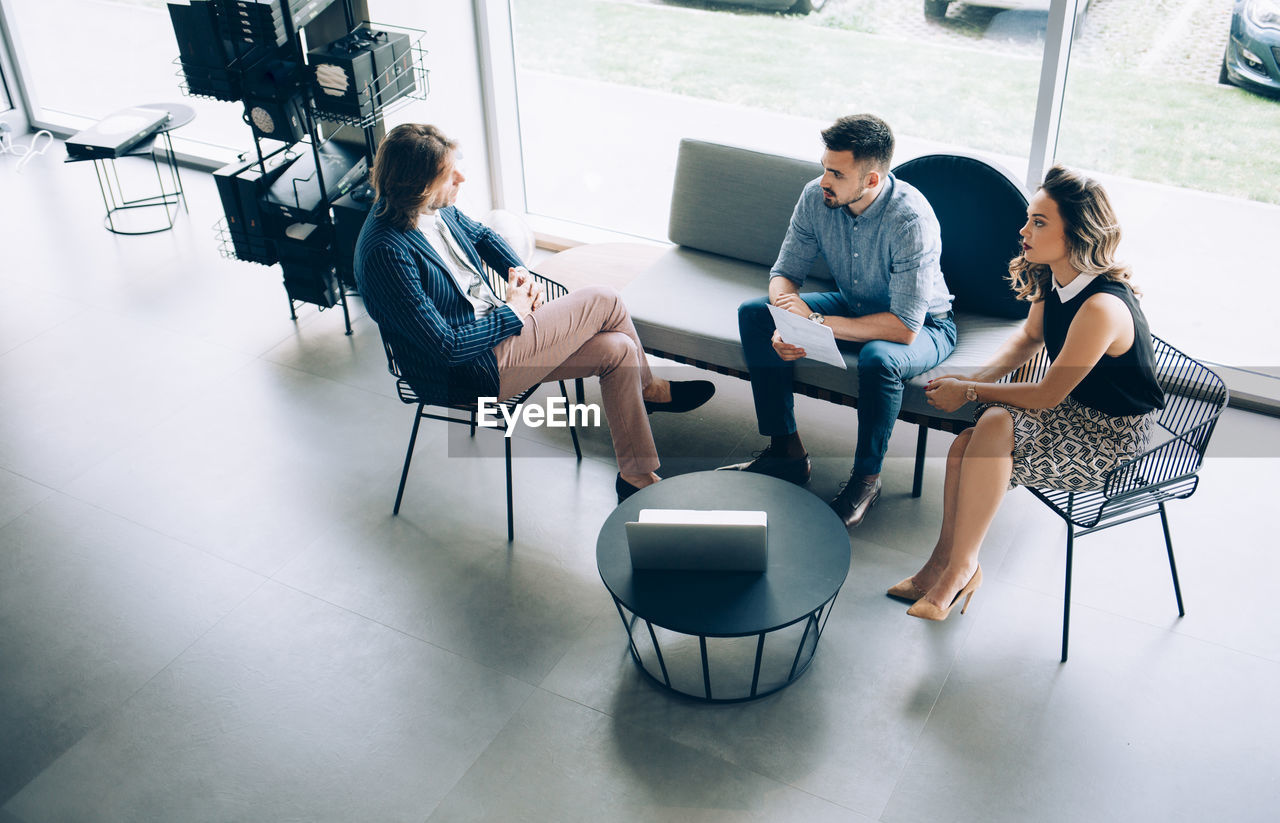 Businessman discussing with colleagues at desk in office