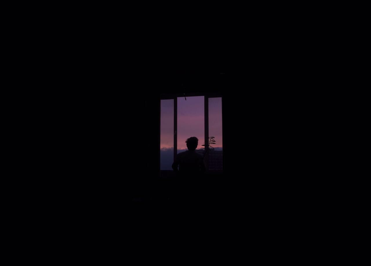 SILHOUETTE OF MAN STANDING IN WINDOW