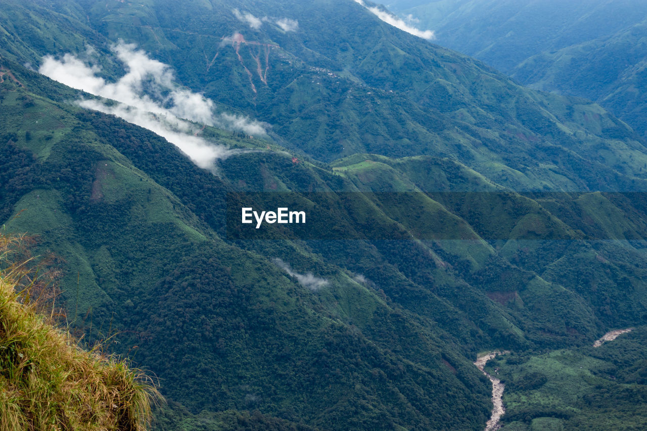 Mountain range downhill peak with light mist at morning from top angle