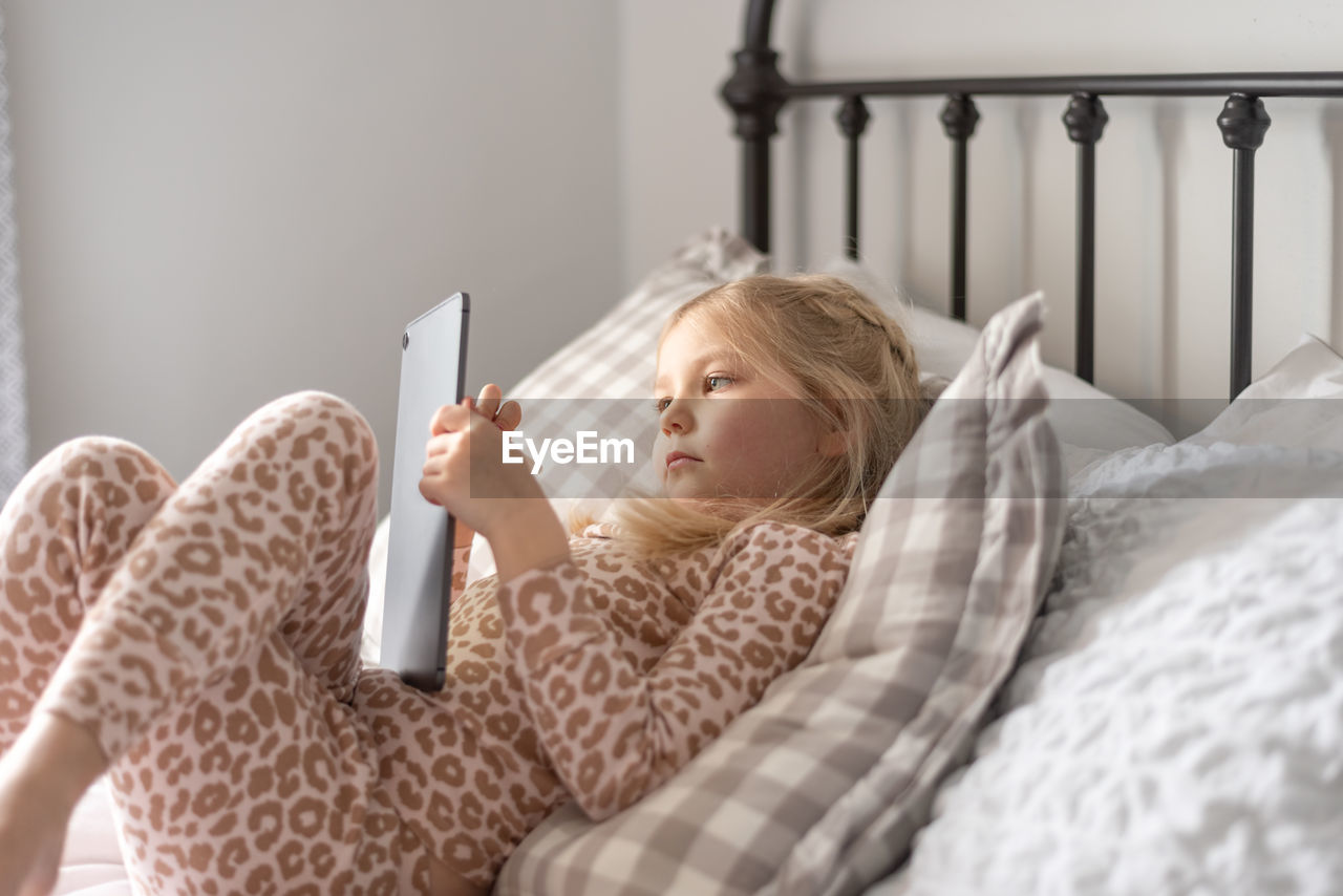 Cute girl using digital tablet at home