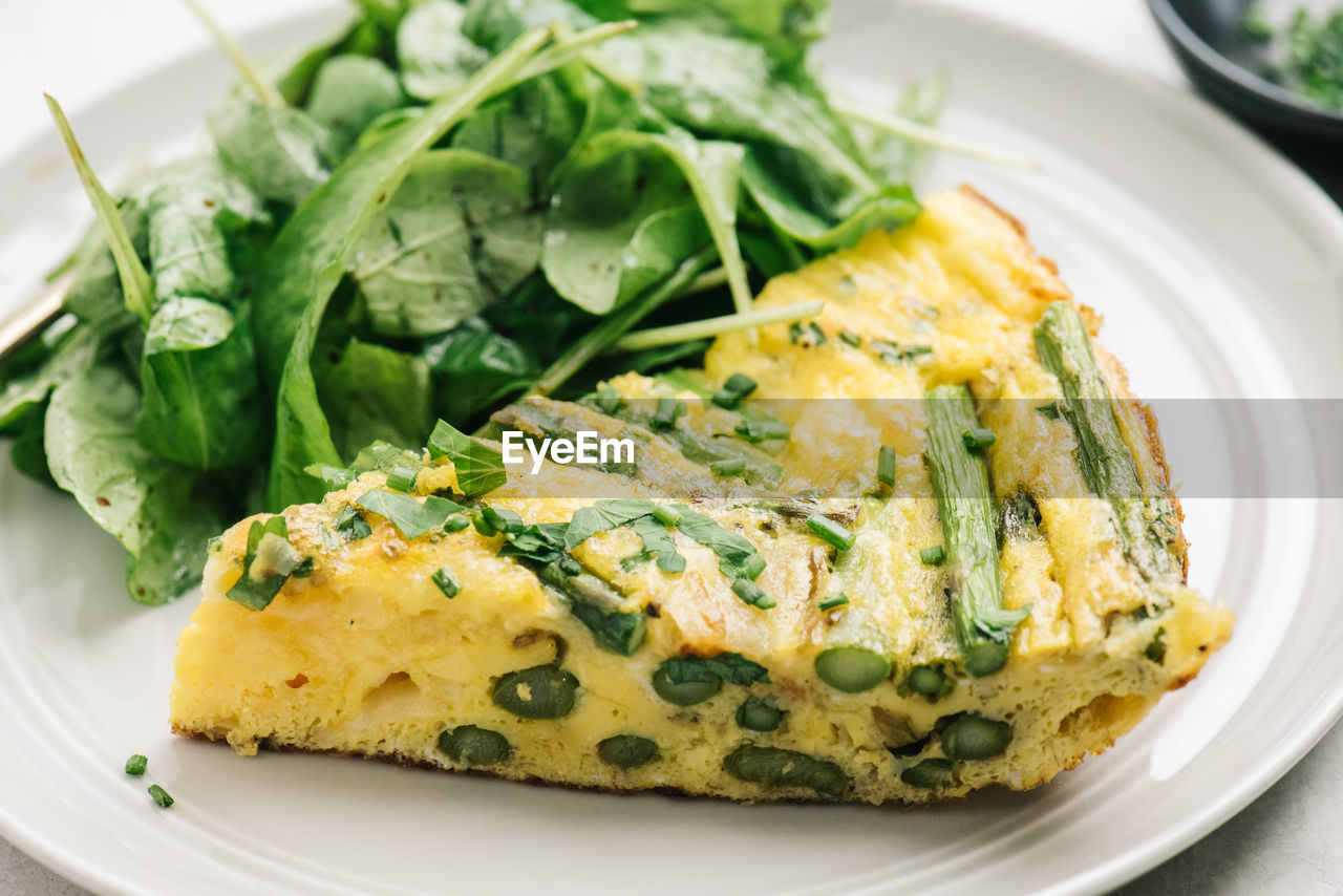 Healthy asparagus frittata meal with arugula salad