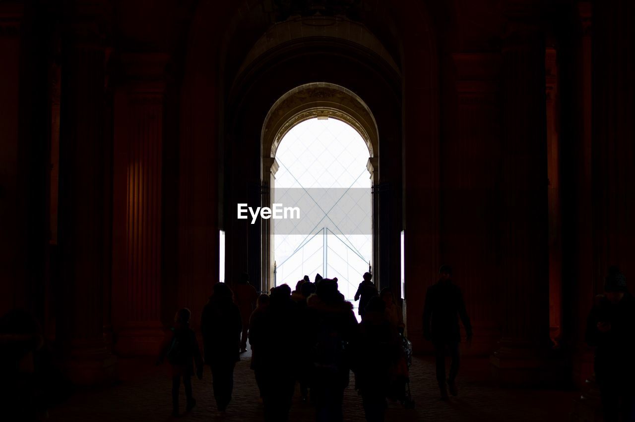 SILHOUETTE OF PEOPLE IN CORRIDOR OF BUILDING