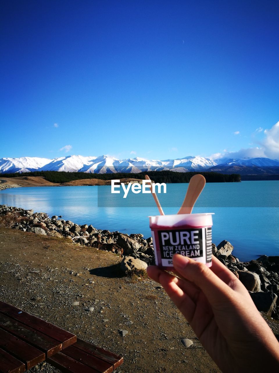 CALM LAKE IN FRONT OF MOUNTAINS AGAINST CLEAR SKY