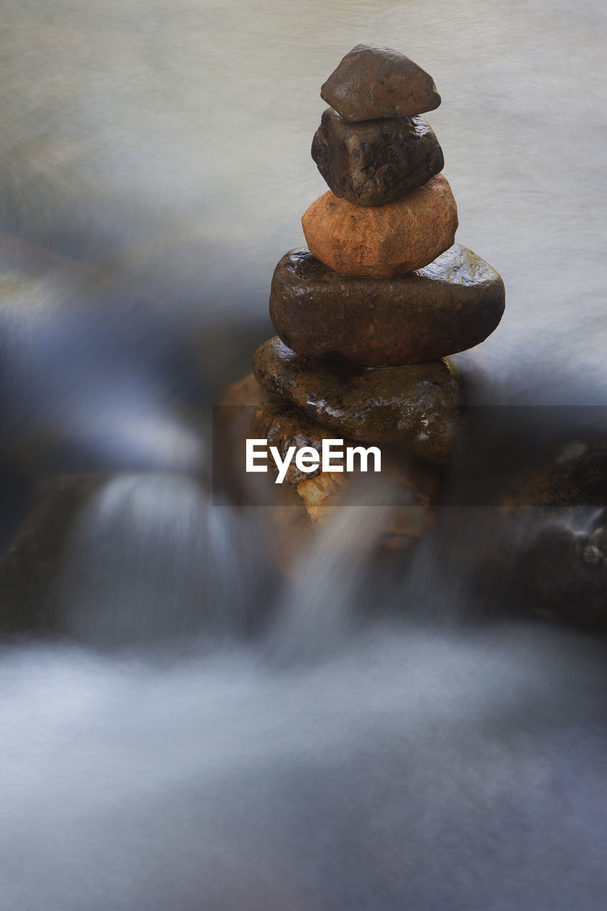 STACK OF STONES IN WATER AT SHORE