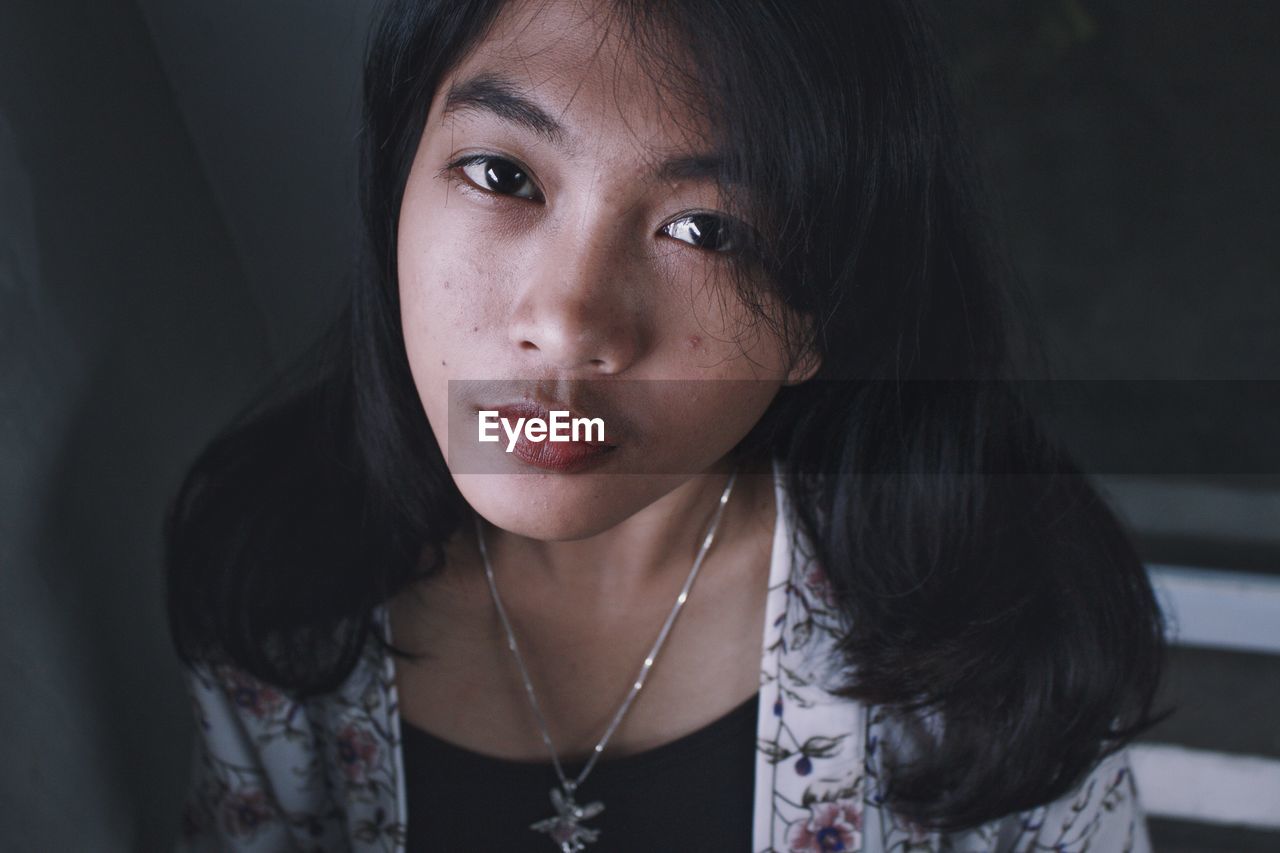 Close-up portrait of young woman at home