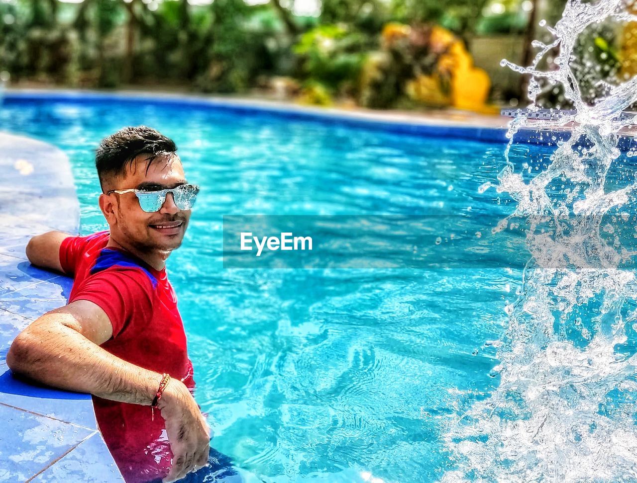 Portrait of man wearing sunglasses in swimming pool