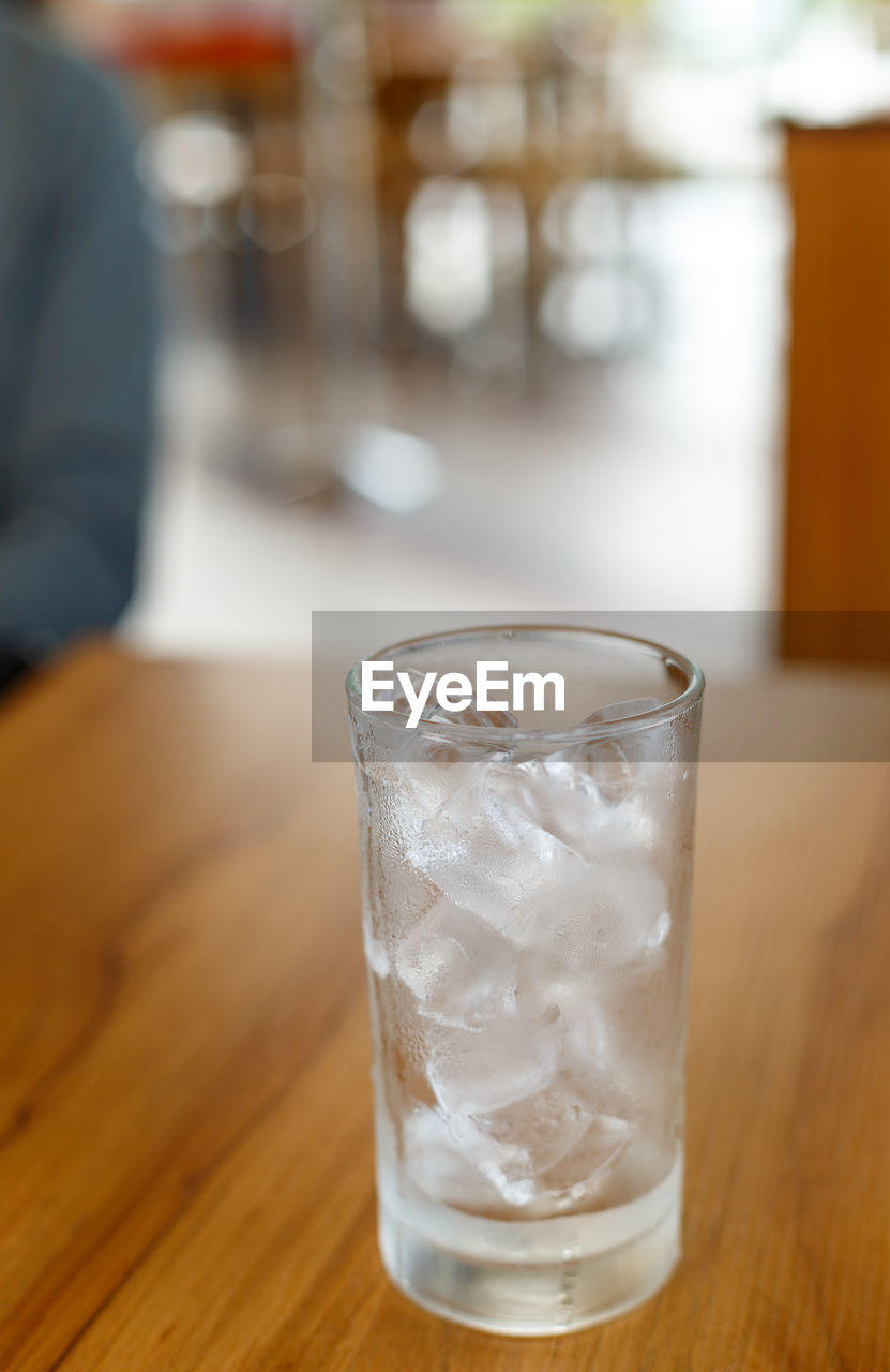 Close-up of ice cubes in drinking glass on table