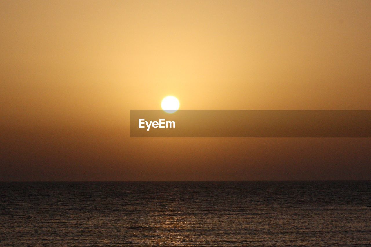 SCENIC VIEW OF SEA AGAINST ORANGE SKY DURING SUNSET