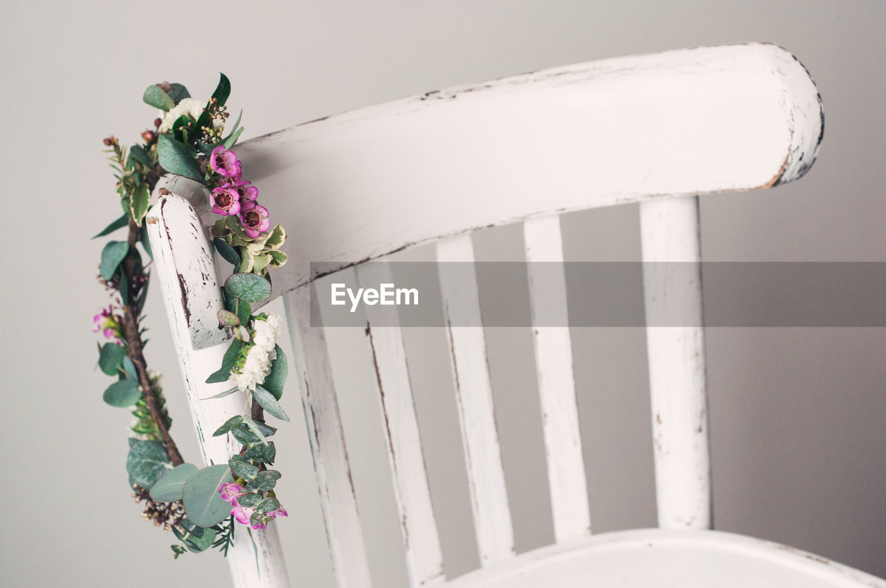 A minimalistic boho rustic bouquet of fresh flowers weighs on a white chair