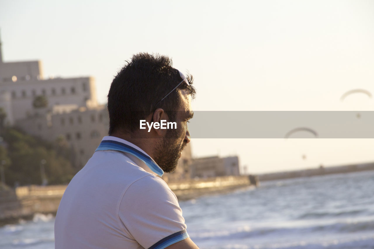 Midsection of man in sea against clear sky